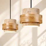 Natural travertine cylinder shades with light wood band, studio close-up