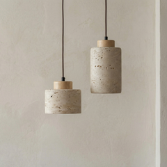 Two stone pendants with light wood caps against a pale wall