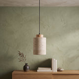 Stone cylinder pendant with a wood cap above a wooden console