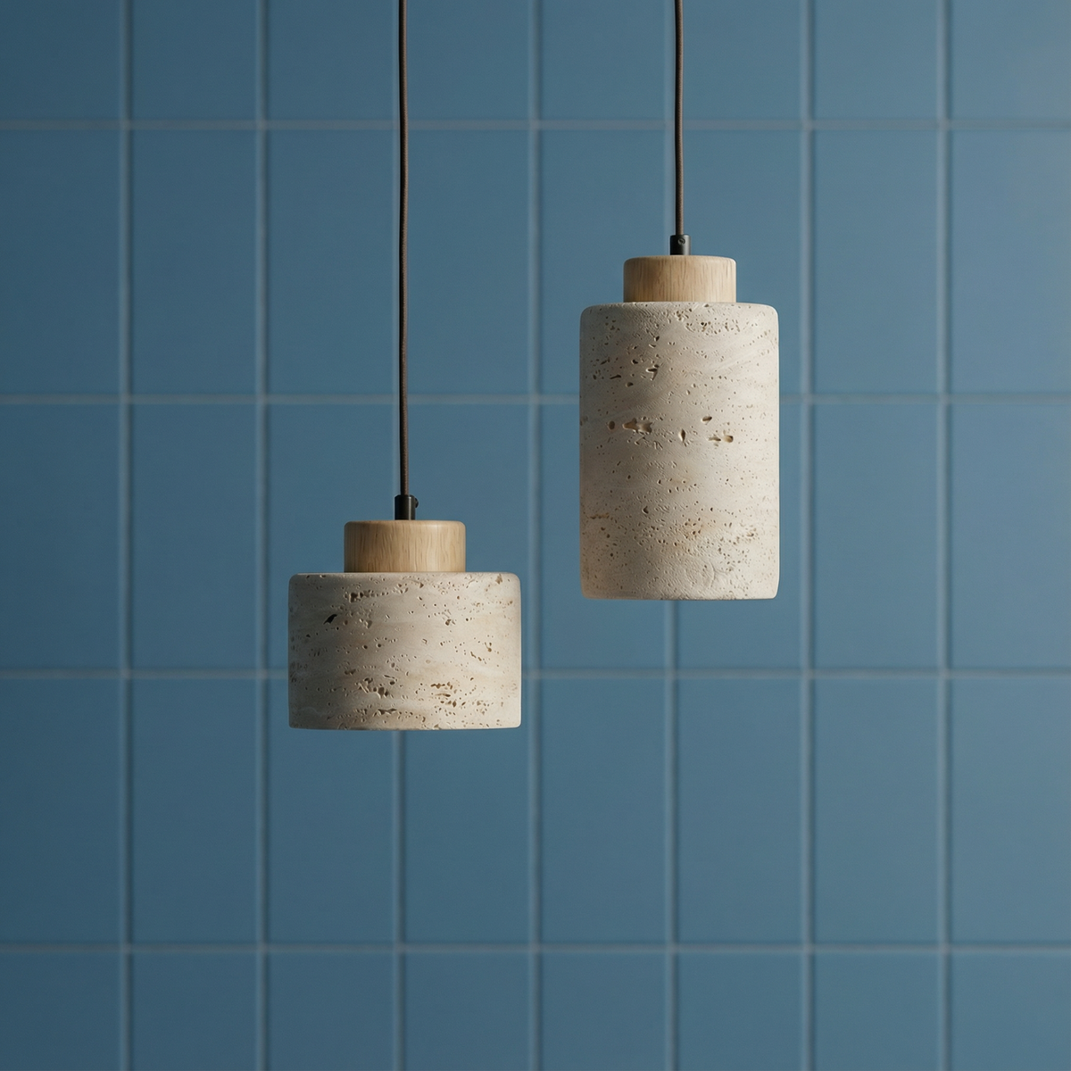 Short and long stone pendants hung against a blue tiled wall
