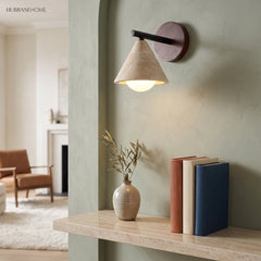 Modern stone wall light above a shelf with books and a vase