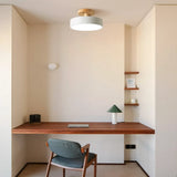 Round ceiling light over a tidy study desk in a calm work corner