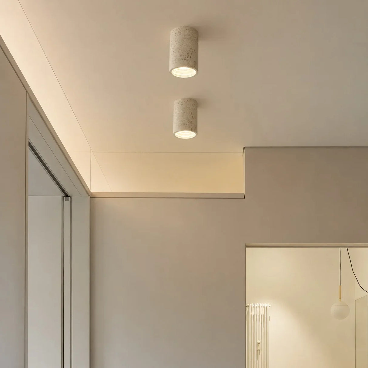 Surface-mount cylinder ceiling light showing porous stone-like surface texture