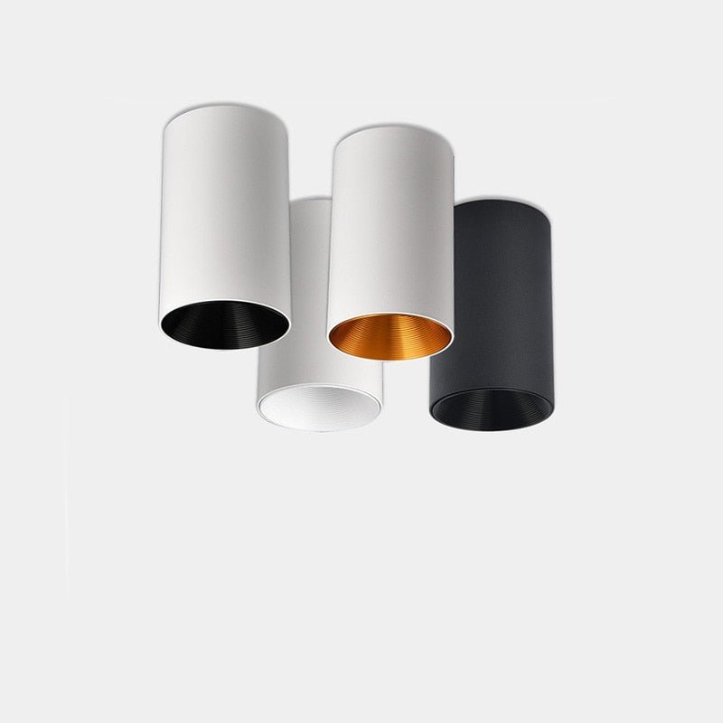 Three white and black cylinder ceiling lights grouped together