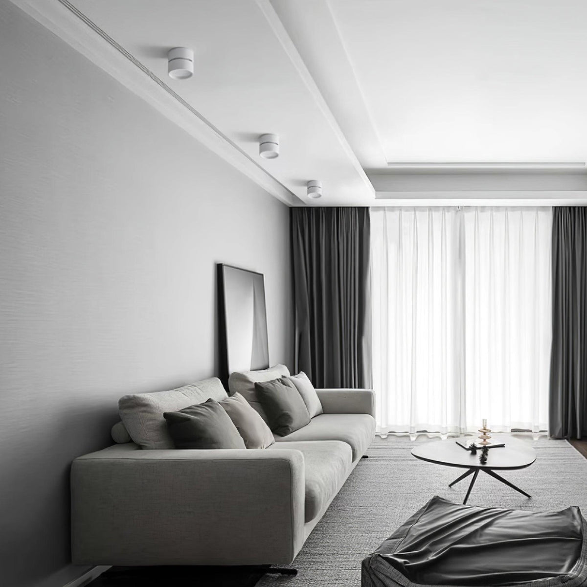 Surface mounted spot lights on a grey bedroom ceiling above a sofa and framed art