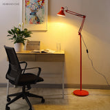 Red reading floor lamp lighting a home office desk and chair
