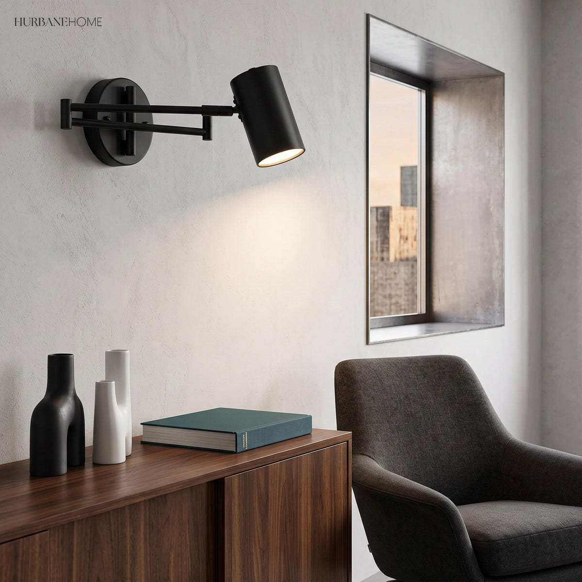 Black swing arm sconce lit above a sideboard and framed mirror