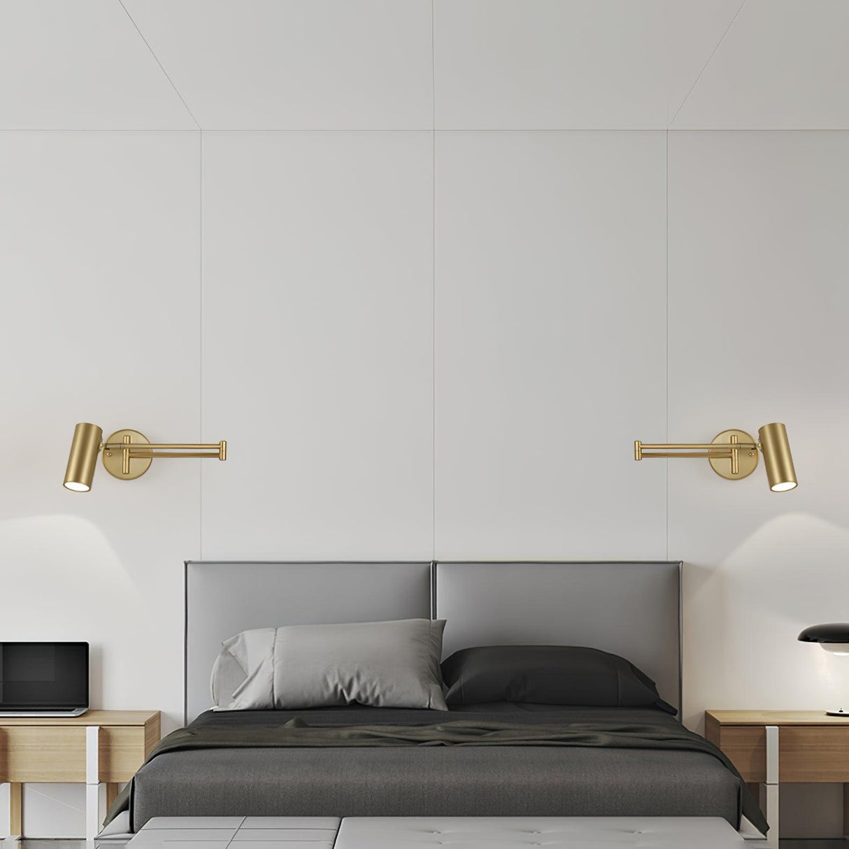 Two gold swing arm sconces flanking a bed with grey bedding