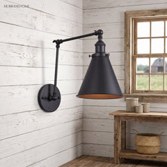 Black swing arm sconce on white shiplap above a rustic side table