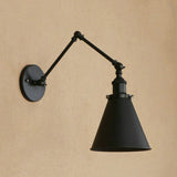 Black swing arm sconce with a cone shade on a warm tan wall