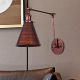 Rust swing arm sconce above a leather sofa beside framed art