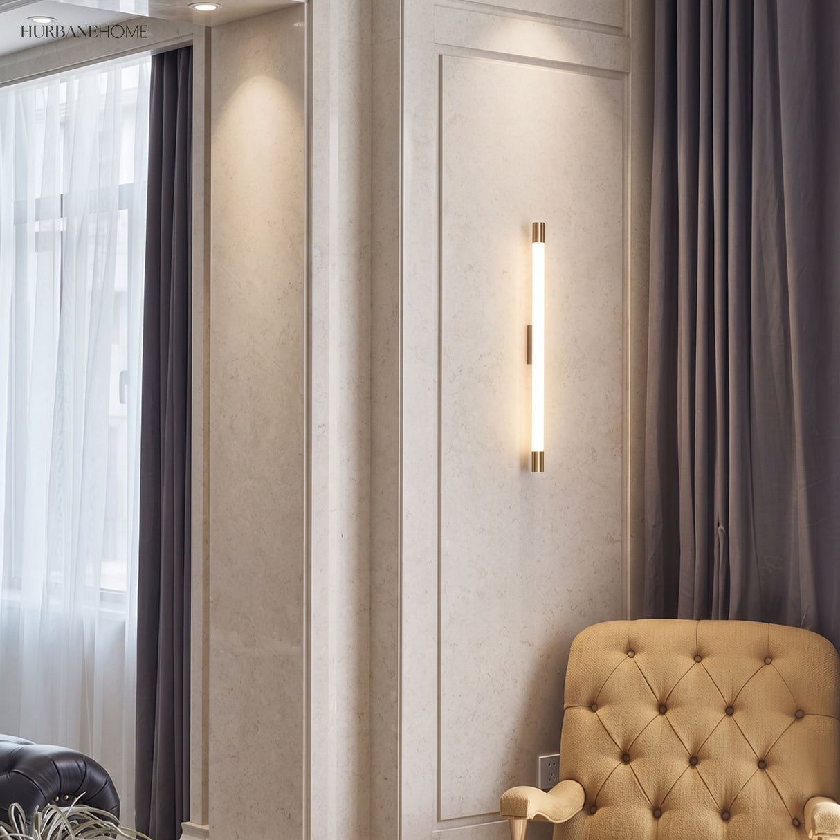 Vertical LED tube sconce beside a window and tufted armchair in a panelled room
