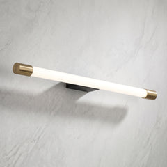 Slim aluminum tube LED wall sconce with brass end caps on a marble wall