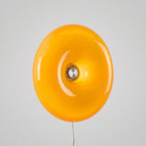 Amber donut-shaped round glass wall light