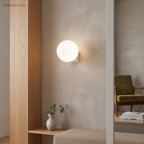Frosted glass globe wall lamp in an entry nook beside a timber bench