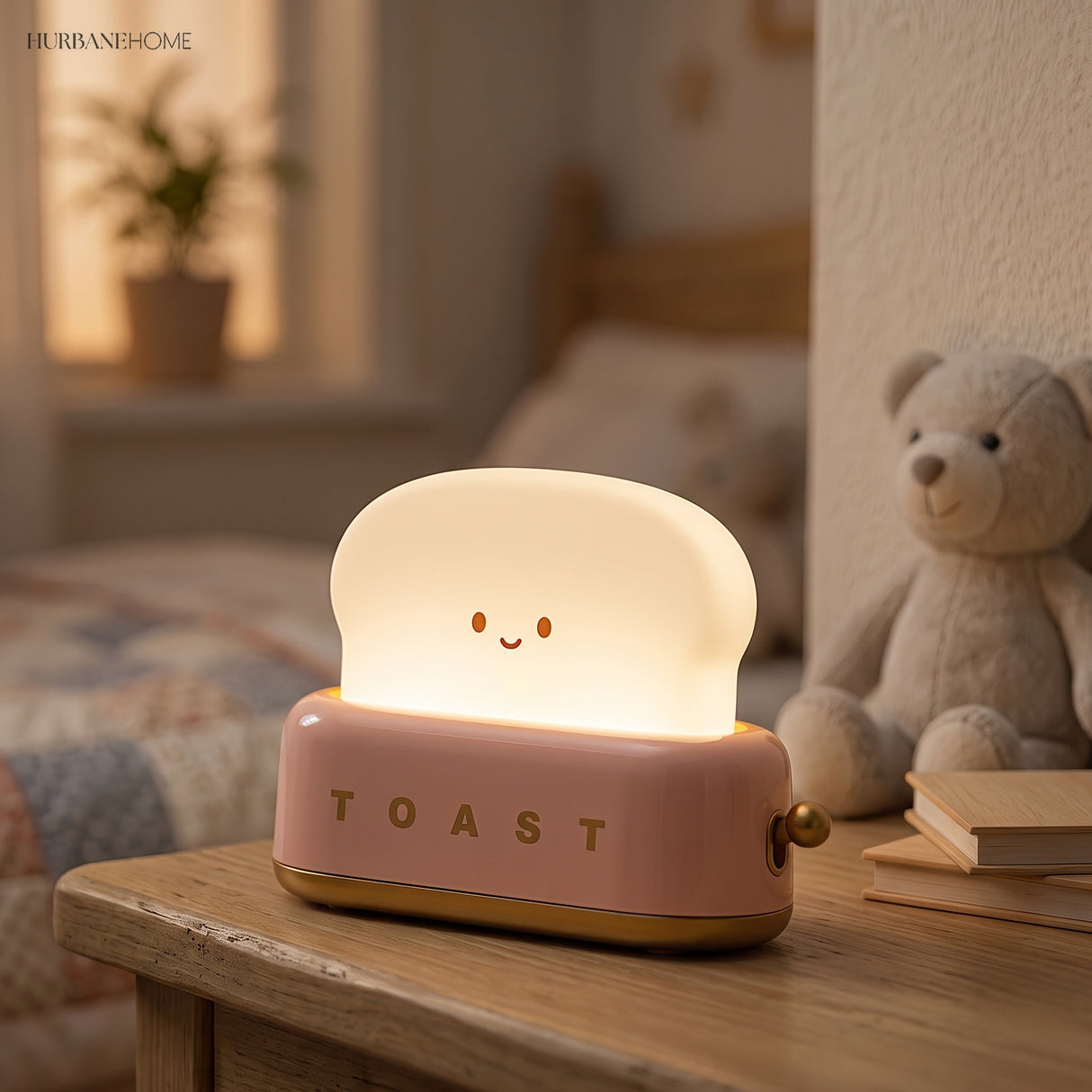 Pink toaster table lamp lit beside a teddy bear in a nursery