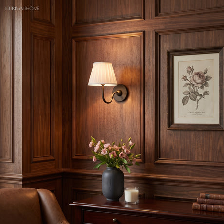 Pleated shade wall sconce lighting a dark wood panelled study corner