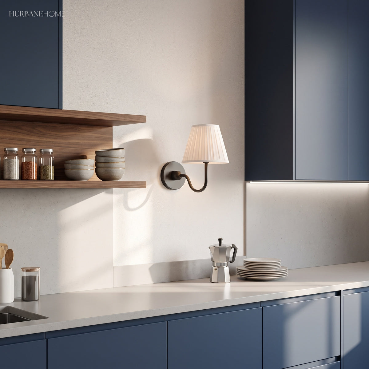 Pleated linen wall sconce mounted between navy kitchen cabinets and shelving