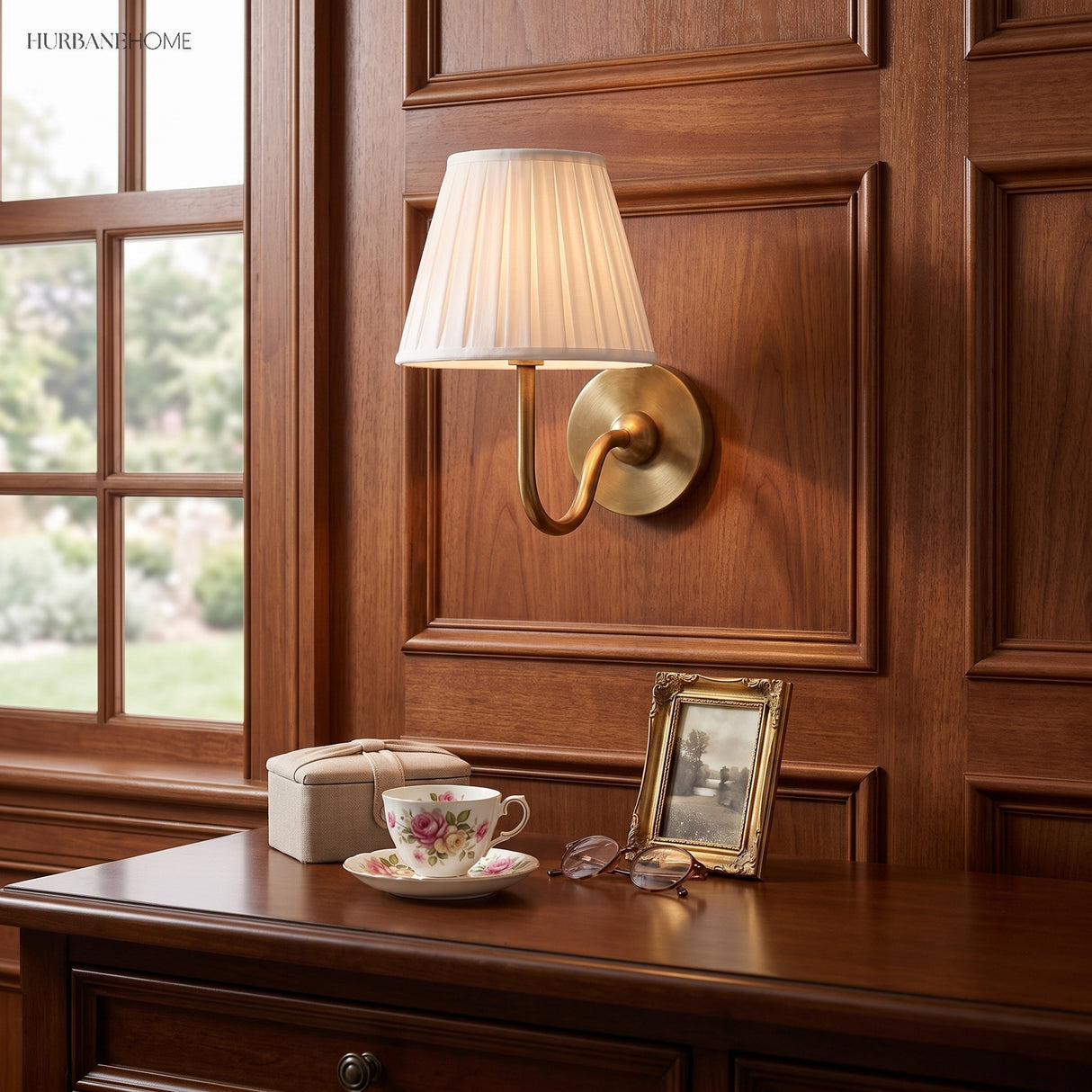 Warm brass pleated linen sconce on walnut panelling above a desk