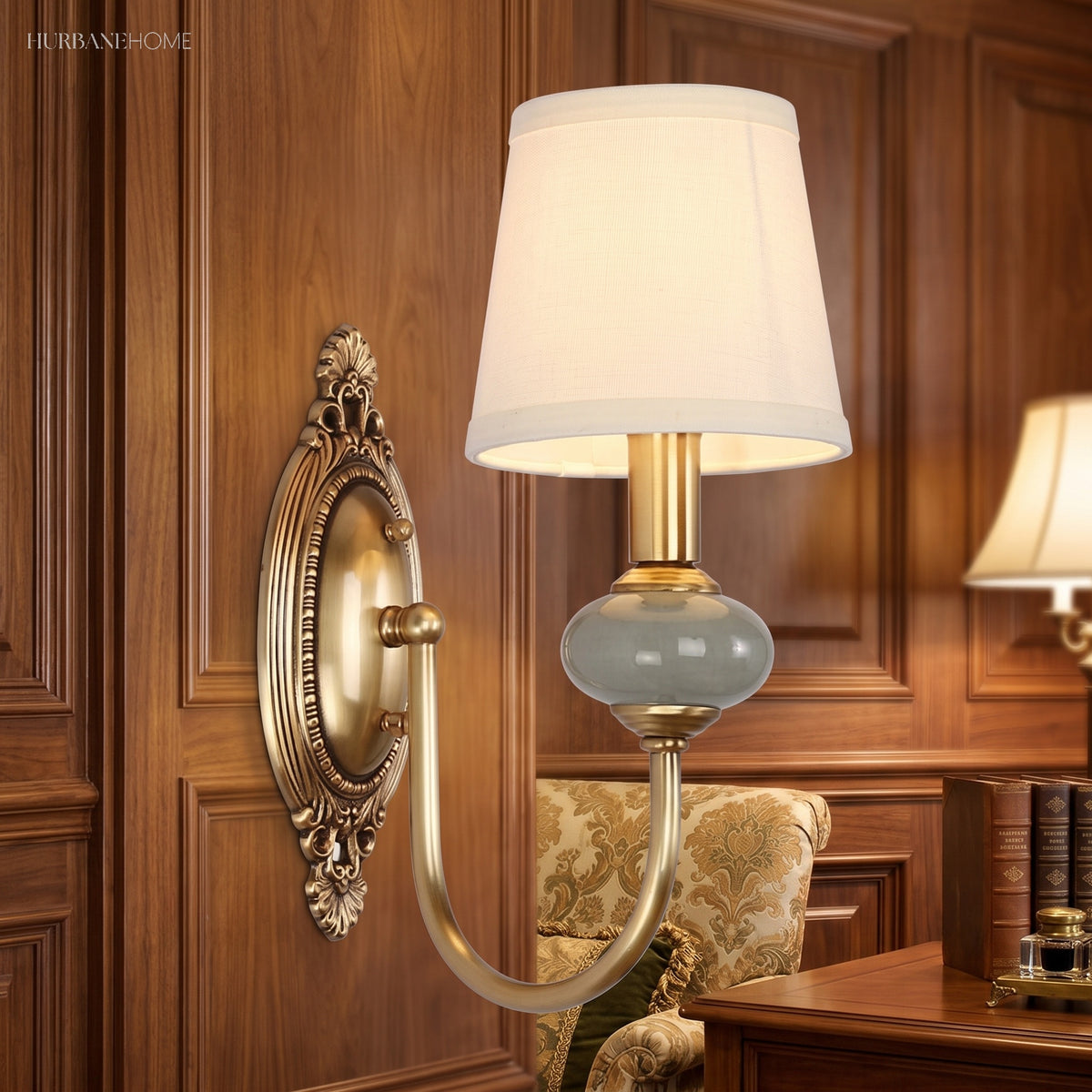 Single gold sconce lit on dark timber panelling beside a mirror