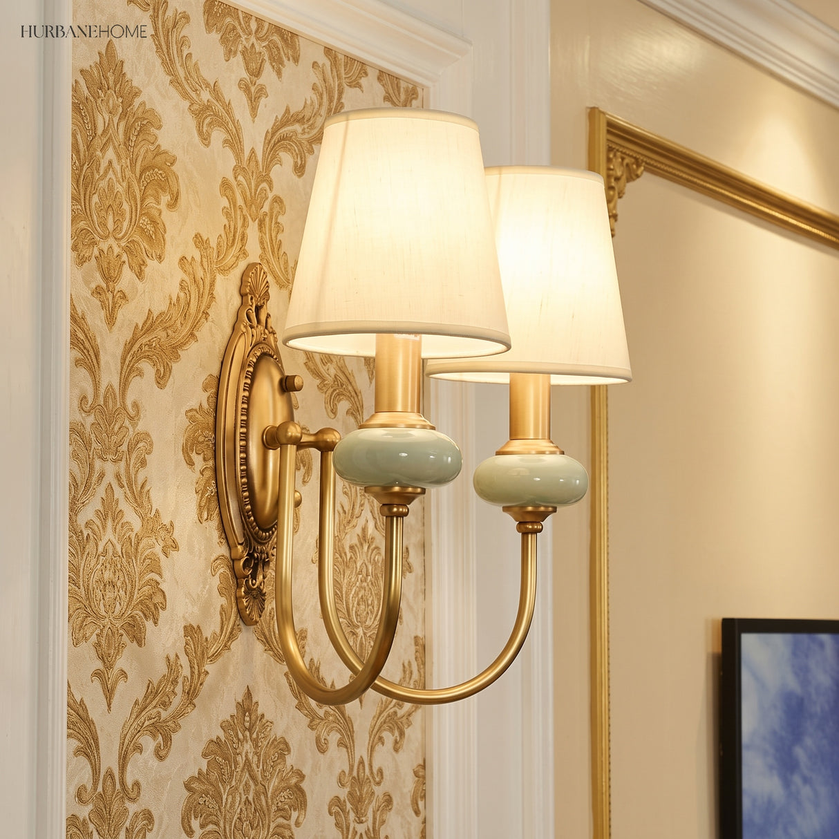 Two light gold sconce lit against gold damask wallpaper