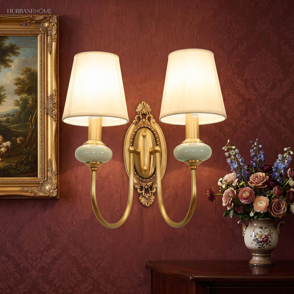 Two light gold sconce on a deep red wall above a flower vase