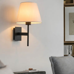 Wall sconce on a white wall above a side table in a living room