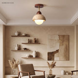 Travertine ceiling light with walnut wood collar in a warm minimalist living room