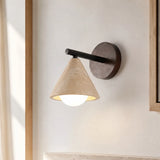 Travertine cone wall sconce mounted on a plaster wall