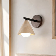 Travertine cone wall sconce mounted on a plaster wall