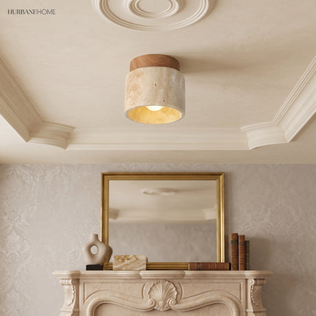 Travertine ceiling light below an ornate plaster ceiling rose and mantel