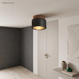 Black collared travertine ceiling light above a dark grey hallway
