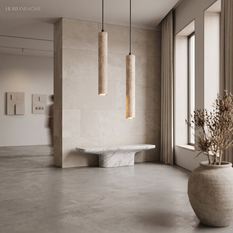 Two travertine cylinder pendants in a pale minimalist stone interior