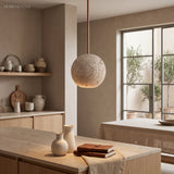 Travertine ball pendant light above a kitchen island and timber counter