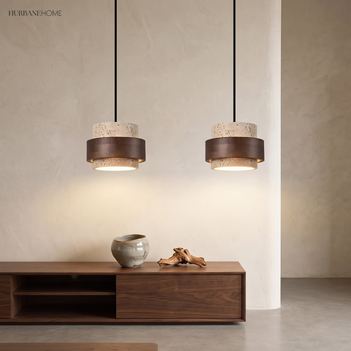 Two travertine and wood pendants above a low dark wood sideboard and vases