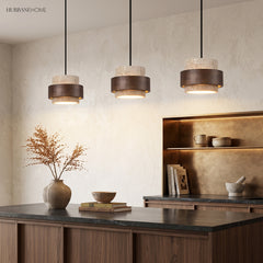 Three travertine and wood pendant lights in a row over a kitchen counter