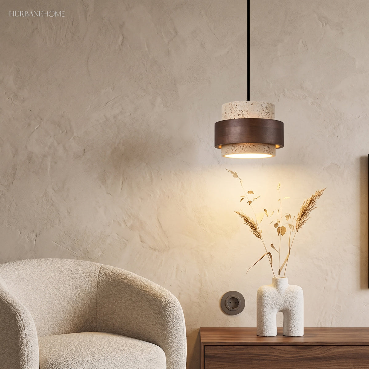 Single travertine and wood pendant beside a cream armchair and plaster wall