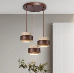 Three staggered pendants on a round dark wood ceiling plate by a radiator