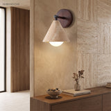 Modern wall sconce lighting a travertine tile wall in a hallway