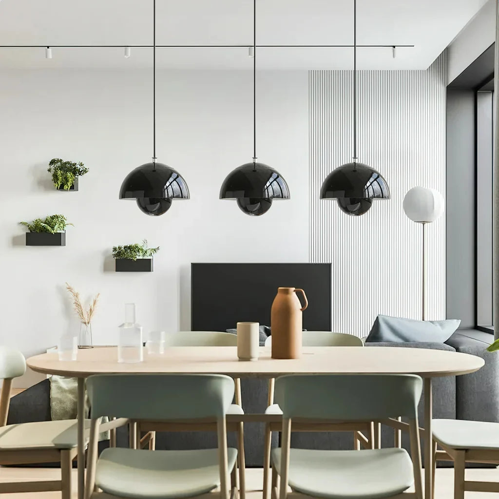 Three bud metal pendant lights hung in a row over a kitchen island