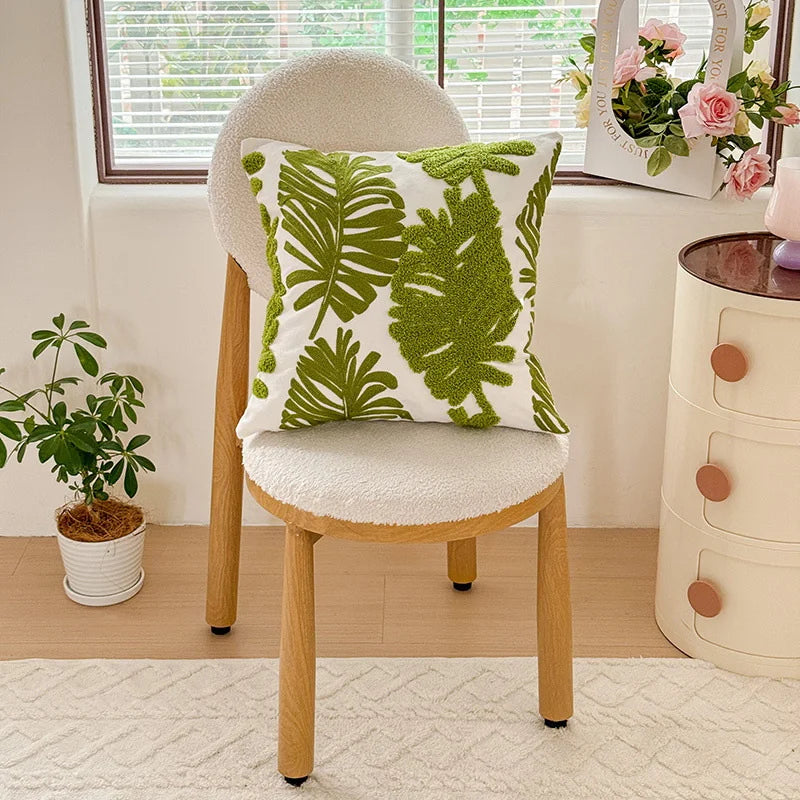 Sofa arrangement featuring botanical decorative pillows with textured stitching