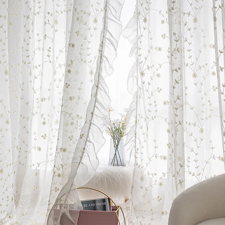 Tulle sheer curtain with embroidery hanging in bright living room