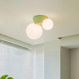 Green canopy globe light lit on a ceiling beside a window with white blinds
