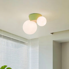 Green canopy globe light lit on a ceiling beside a window with white blinds