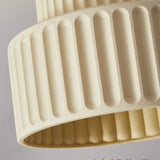 Two-tier fluted ceiling light presented at an angle on a plain grey backdrop