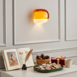 Two-tone glass wall light shown beside home furnishings in a lifestyle scene