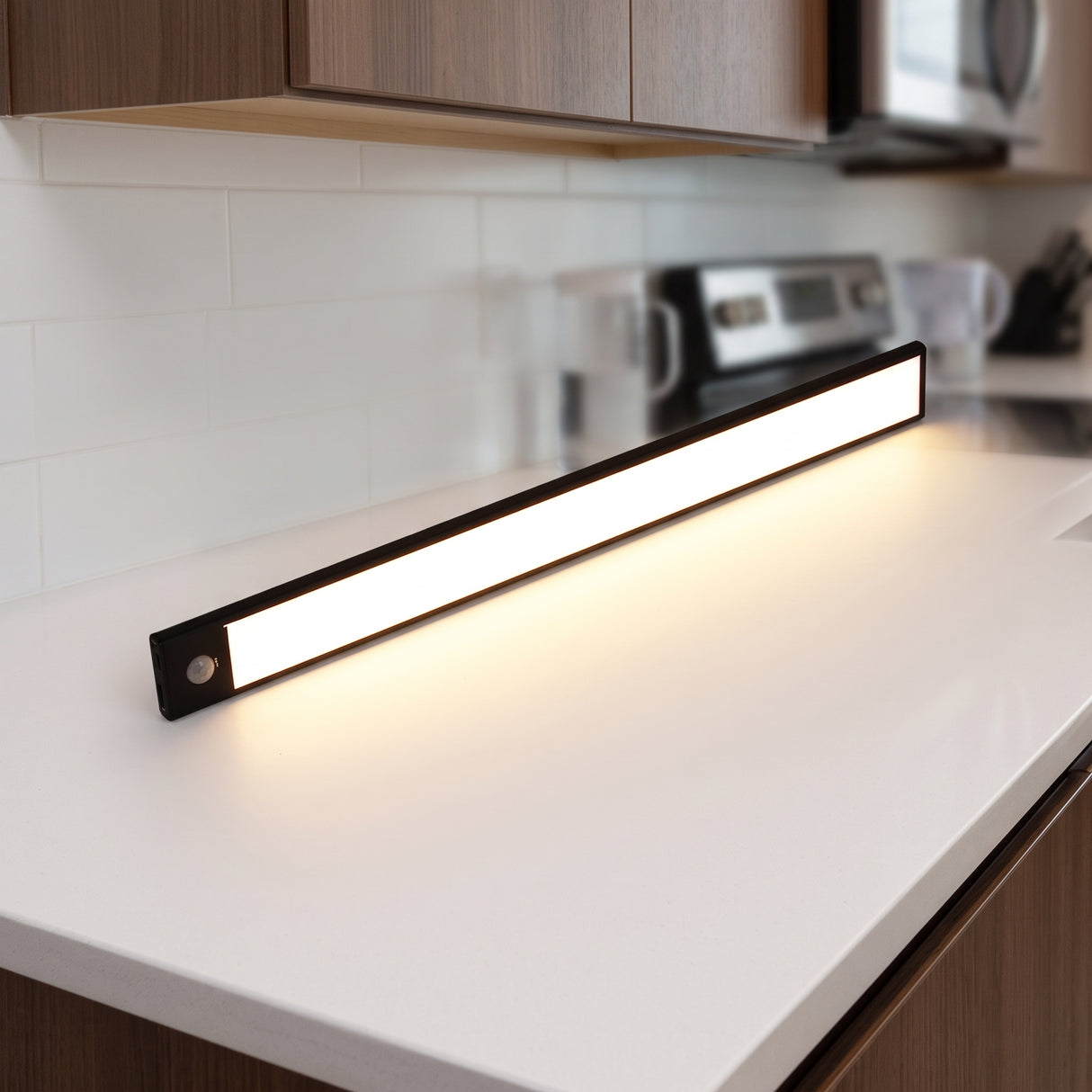 Black LED bar lighting a white kitchen counter from under a cabinet