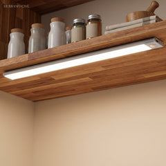 Light bar under a wood shelf lighting spice jars and a worktop