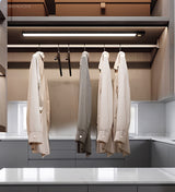 Light bars fitted above a wardrobe rail of hanging white shirts