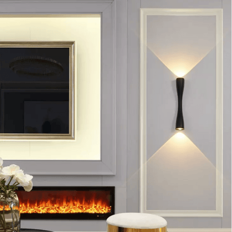 White slim wall light lit on a panelled wall beside a fireplace